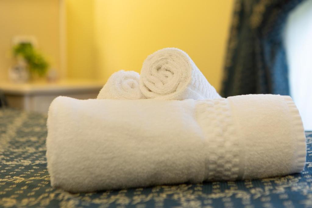 rolka białych ręczników na łóżku w obiekcie Annette B&B w Rzymie