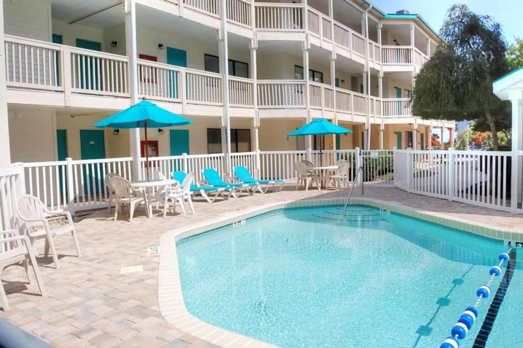 a pool in front of a hotel with chairs and umbrellas at Ocean Dunes Villa I 5110 & 5111 in Myrtle Beach