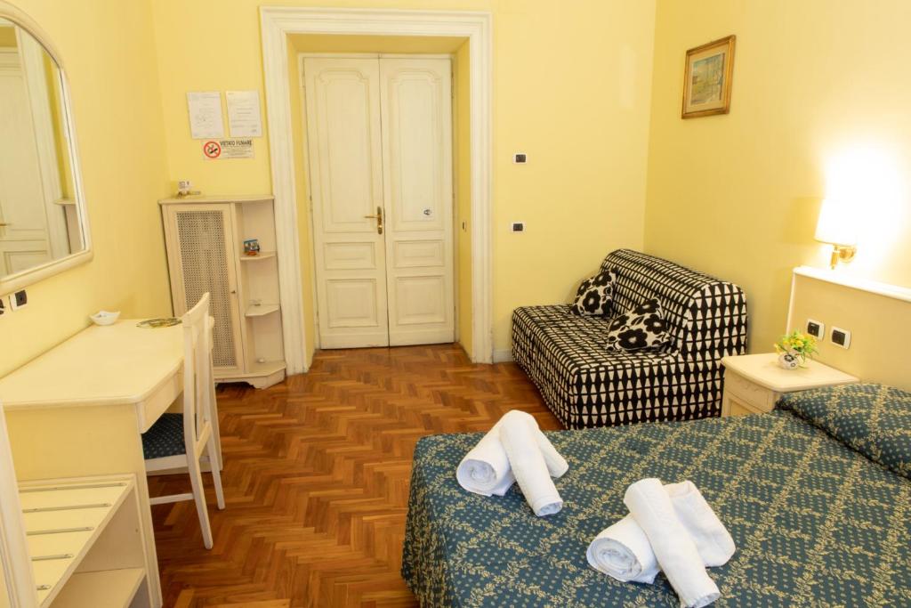 um quarto com duas camas, um sofá e uma mesa em Annette B&B em Roma