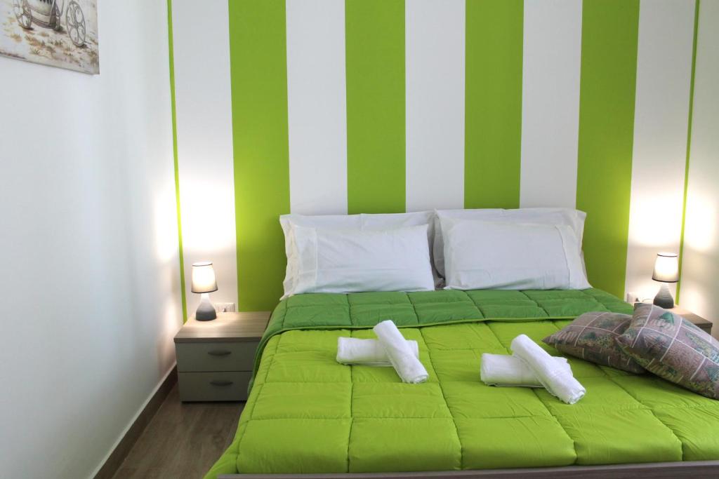 un letto verde con due cuscini bianchi di Charm Central a Reggio di Calabria