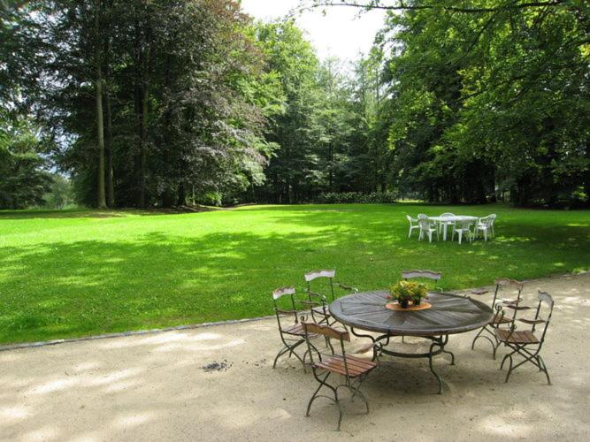 un tavolo e sedie in un parco con prato di Mansion in Beauplateau near Forest a Gérimont