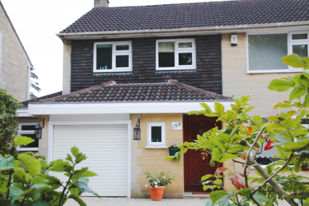 uma casa com uma garagem branca e um telhado preto em Zen House Bath em Bath