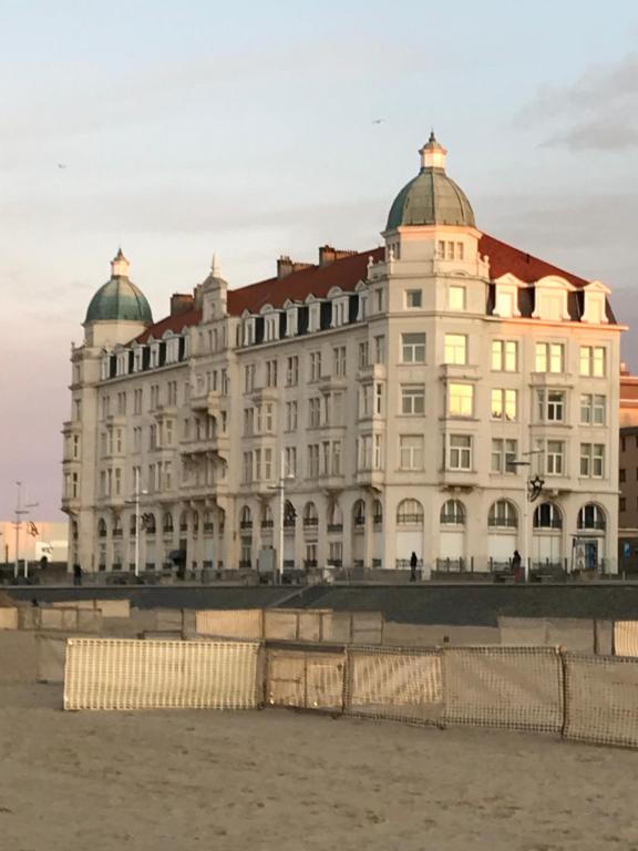 een groot wit gebouw met een rood dak bij Residentie Palace Zeebrugge in Zeebrugge