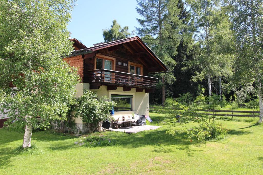 a log house with a balcony and a yard at Chalet Berghof in Seefeld in Tirol