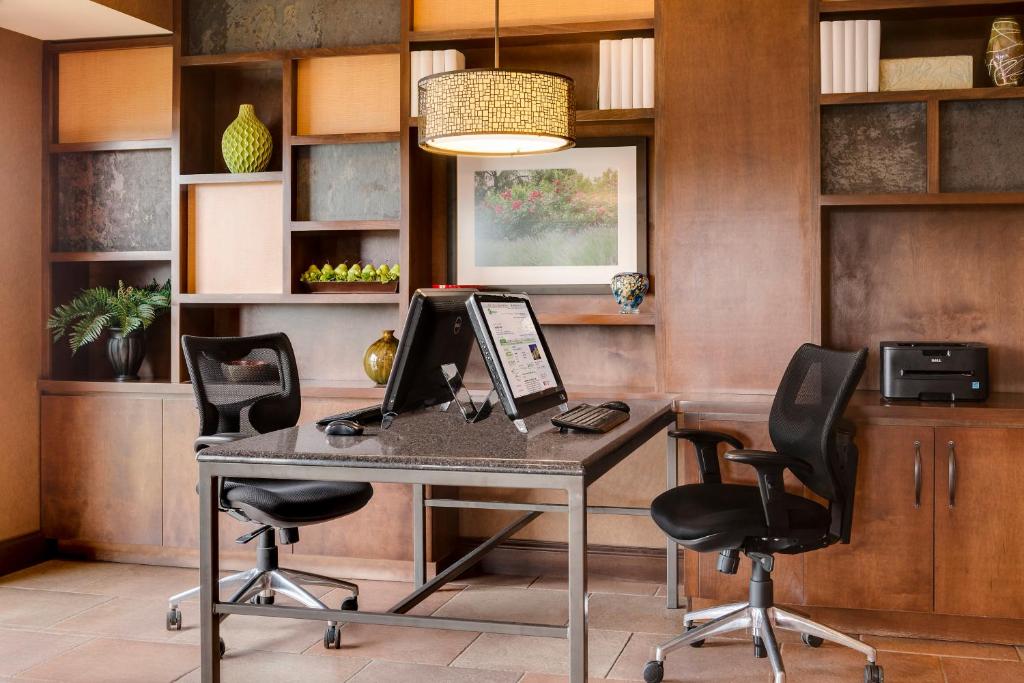 una oficina con escritorio, ordenador portátil y 2 sillas en Holiday Inn Hotel & Suites Council Bluffs, an IHG Hotel, en Council Bluffs