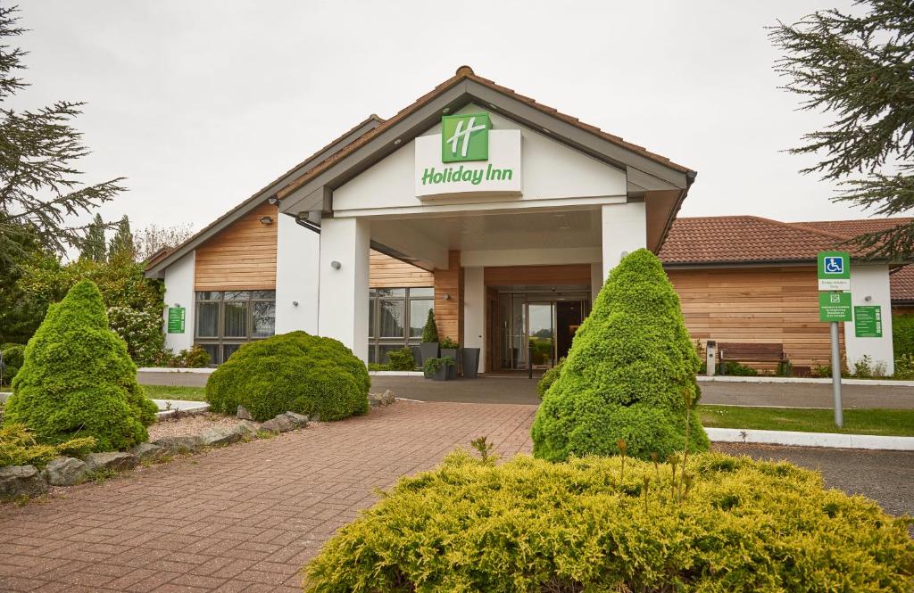 a building with a sign on the front of it at Holiday Inn Northampton West M1 Junc 16, an IHG Hotel in Northampton