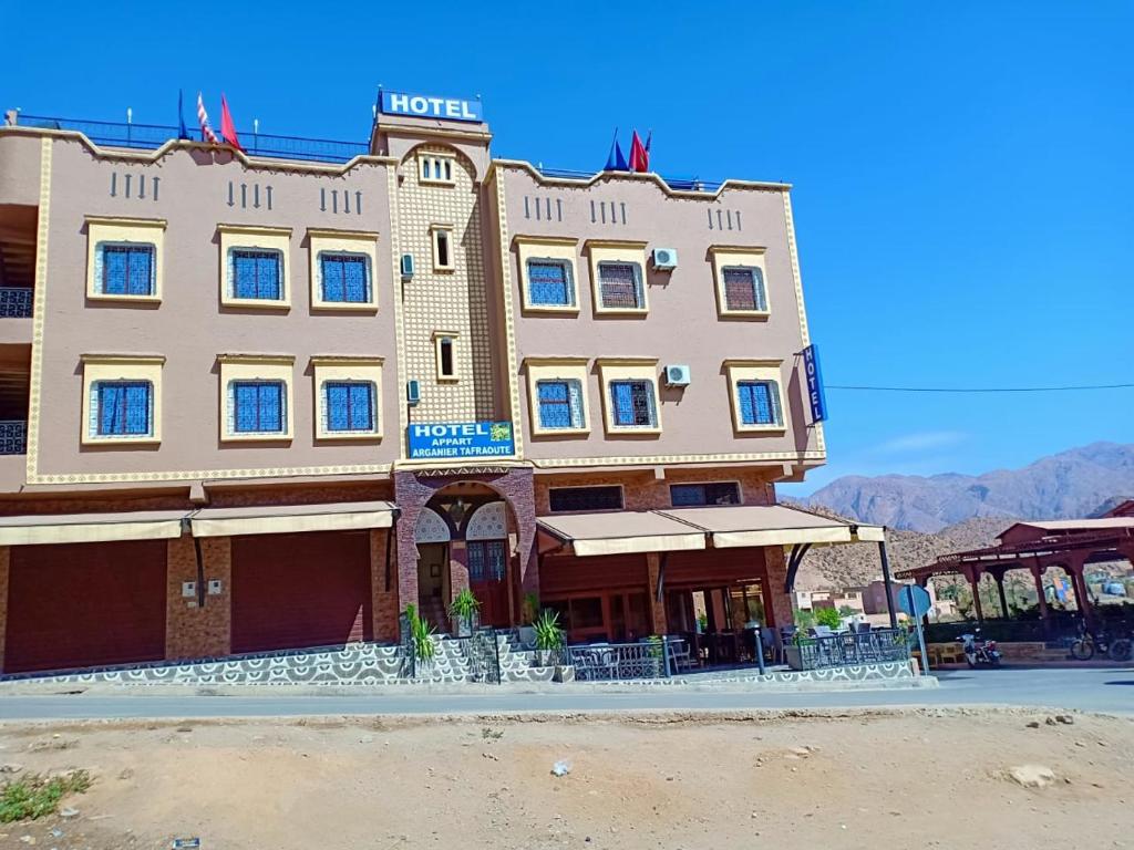 a building with a hotel on the side of a street at hotel arganier tafraoute in Tafraoute