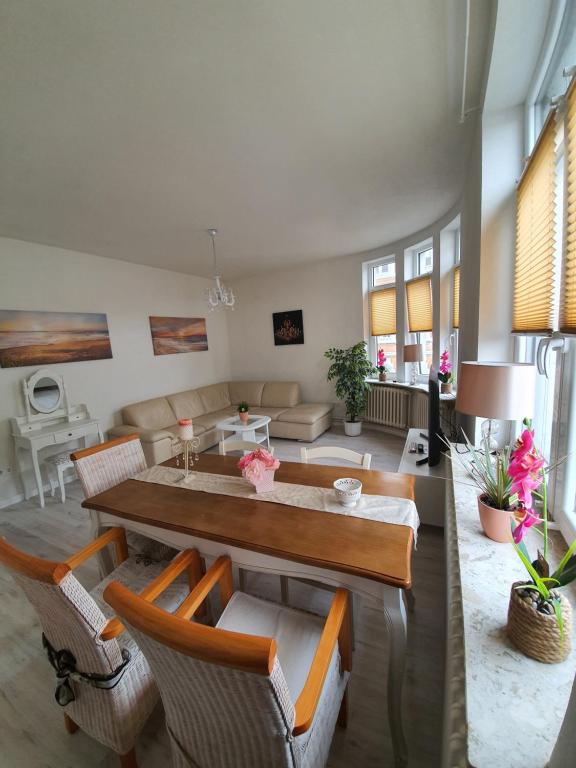 een woonkamer met een tafel en stoelen bij Husum Zentrum bis 7 Personen. in Husum