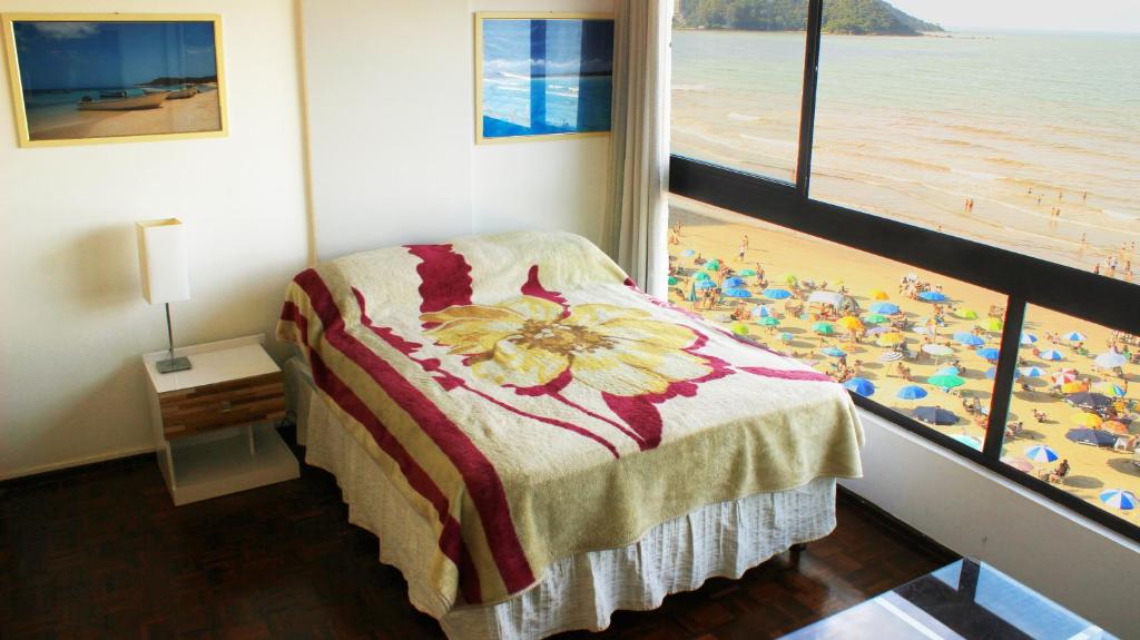 1 dormitorio con cama y vistas a la playa en Totalmente de Frente ao Mar, en Balneário Camboriú