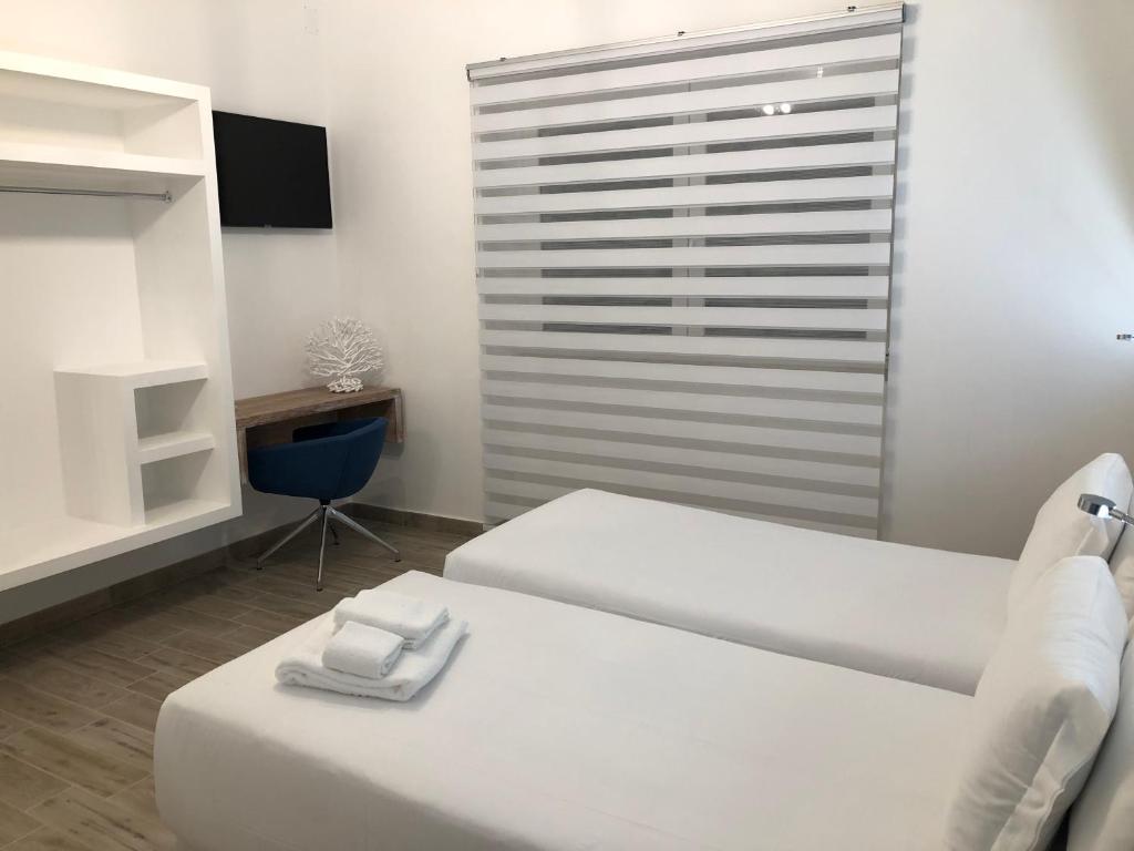 Zimmer mit 2 Betten, einem Tisch und einem Stuhl in der Unterkunft B&B Villa S.Anna in Bari