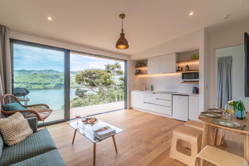 Treetop Retreat - Takamatua Holiday Home في Takamatua Bay: مطبخ وغرفة معيشة مع نافذة كبيرة