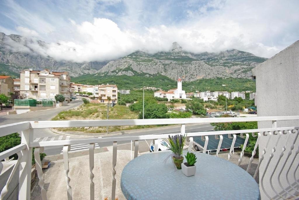 a table on a balcony with a view of a mountain at Apartments Mila - 2 bedrooms and free parking in Makarska
