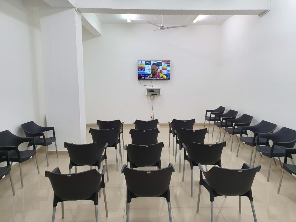 a room with chairs and a tv on a wall at Oasis Residence in Durban