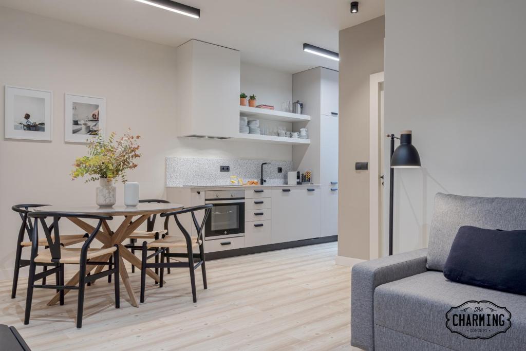 une cuisine et un salon avec une table et un canapé dans l'établissement Retiro Chic - Apartamento de 1 dormitorio, à Madrid