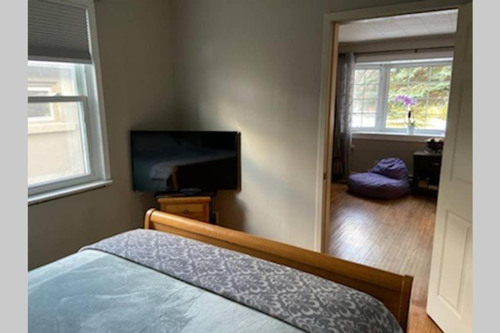 a bedroom with a bed and a tv and a mirror at The Nottawa Gem, Blue Mountain & Collingwood in Nottawa