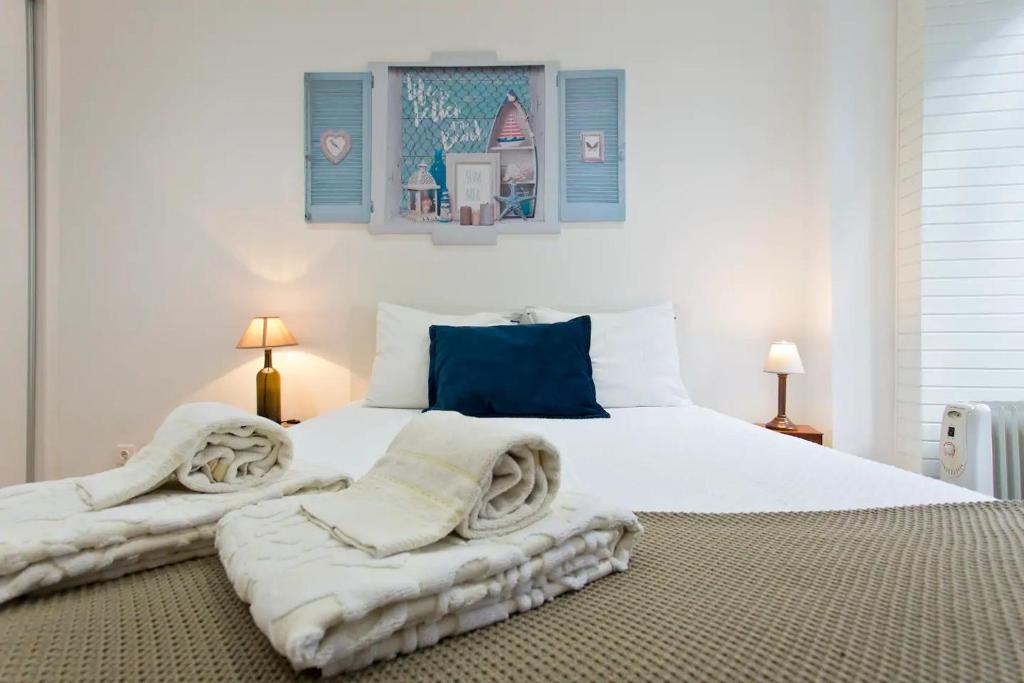 a bedroom with a large white bed with towels on it at Beautiful & Calm In Formosa in Porto