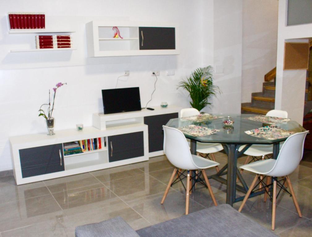 瓦倫西亞的住宿－Apartamento Luminoso cerca de la PLAYA y PUERTO，一间设有玻璃桌和白色椅子的用餐室