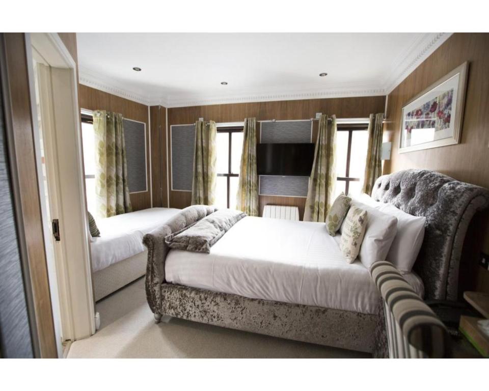 salon z 2 łóżkami i kanapą w obiekcie Cheshire Hotel Central London w Londynie