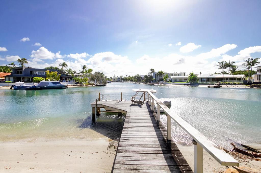 a dock on a body of water with boats at Waterfront on Witta Circle in Noosa Heads