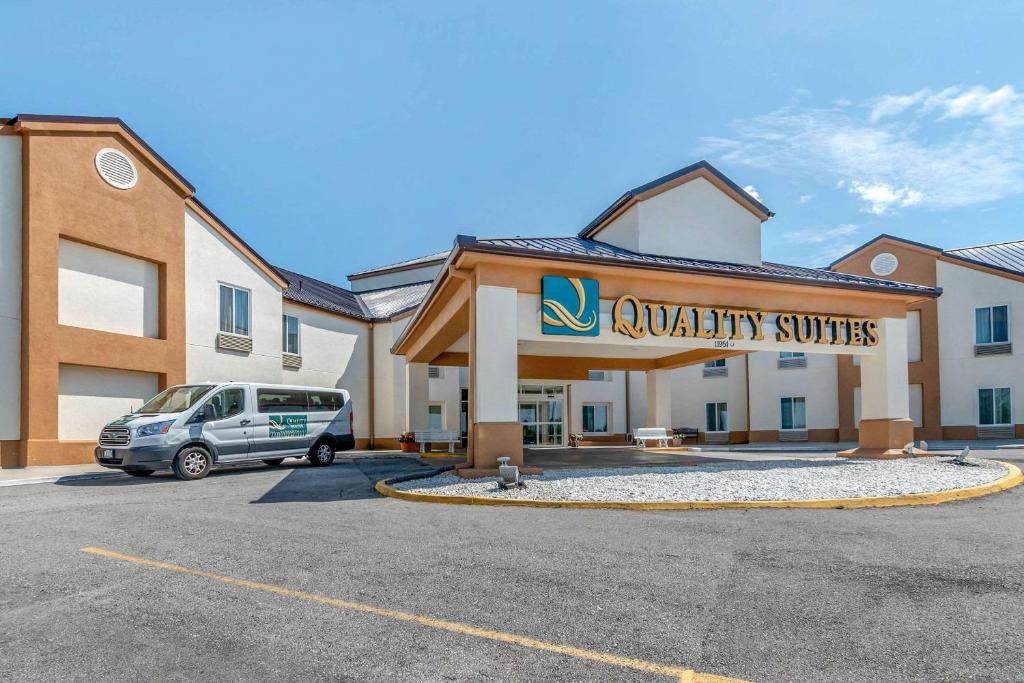 una furgoneta estacionada en un estacionamiento frente a un hotel en Quality Suites Kansas City International Airport en Kansas City