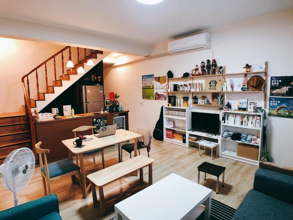 a living room with a table and chairs and a staircase at 1981 Hostel in Taitung City