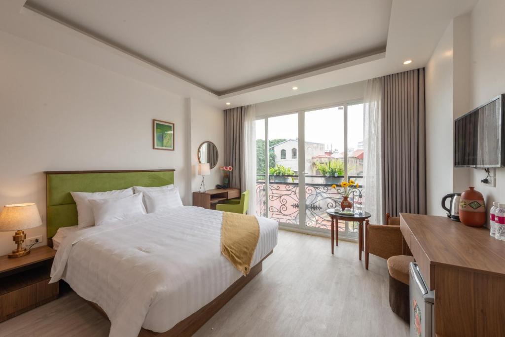 Cette chambre d'hôtel comprend un lit et un balcon. dans l'établissement AMI Old Quarter Hotel, à Hanoï