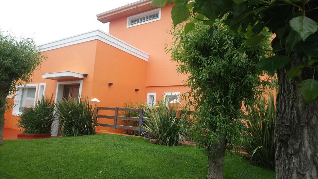 pomarańczowy dom z zielonym dziedzińcem w obiekcie El Buen Descanso w mieście Río Gallegos