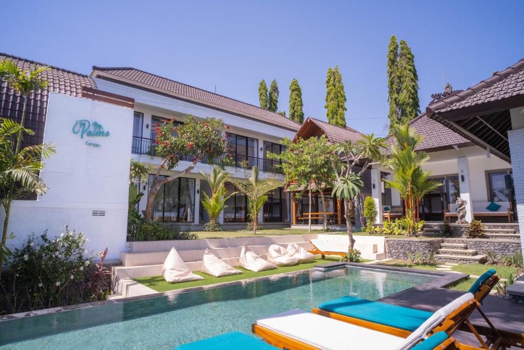 a swimming pool in front of a building with a resort at The Palms Canggu in Canggu