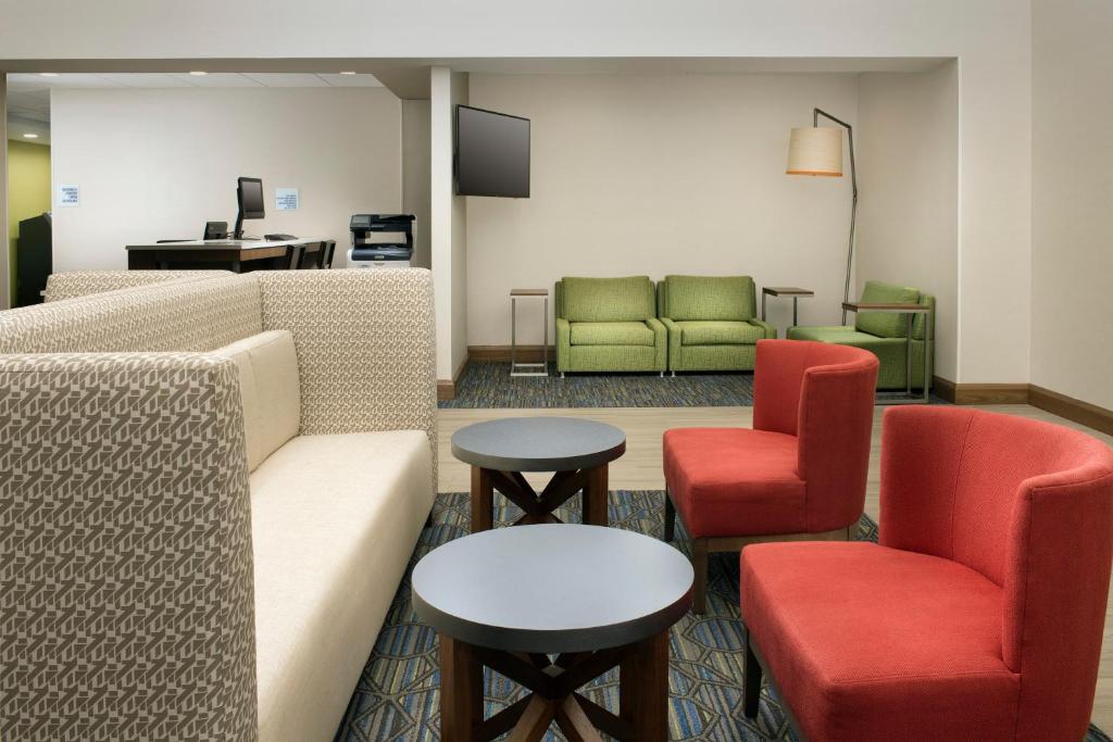 林西肯高地的住宿－巴爾蒂摩快捷智選假日酒店-BWI北機場，一间设有椅子、一张沙发和桌子的等候室