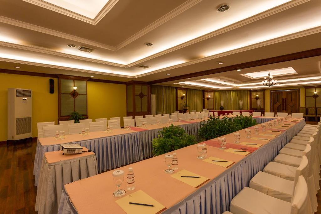 a large room with rows of tables and white chairs at Prince Angkor Hotel & Spa in Siem Reap