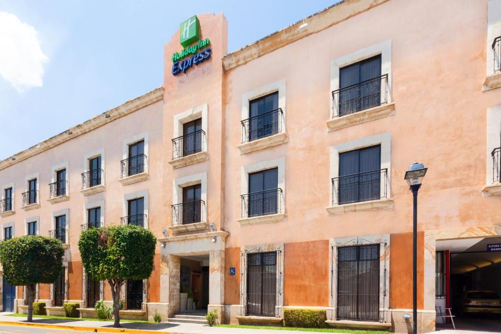 um edifício laranja com um cartaz em Holiday Inn Express Oaxaca - Centro Historico, an IHG Hotel em Oaxaca de Juárez