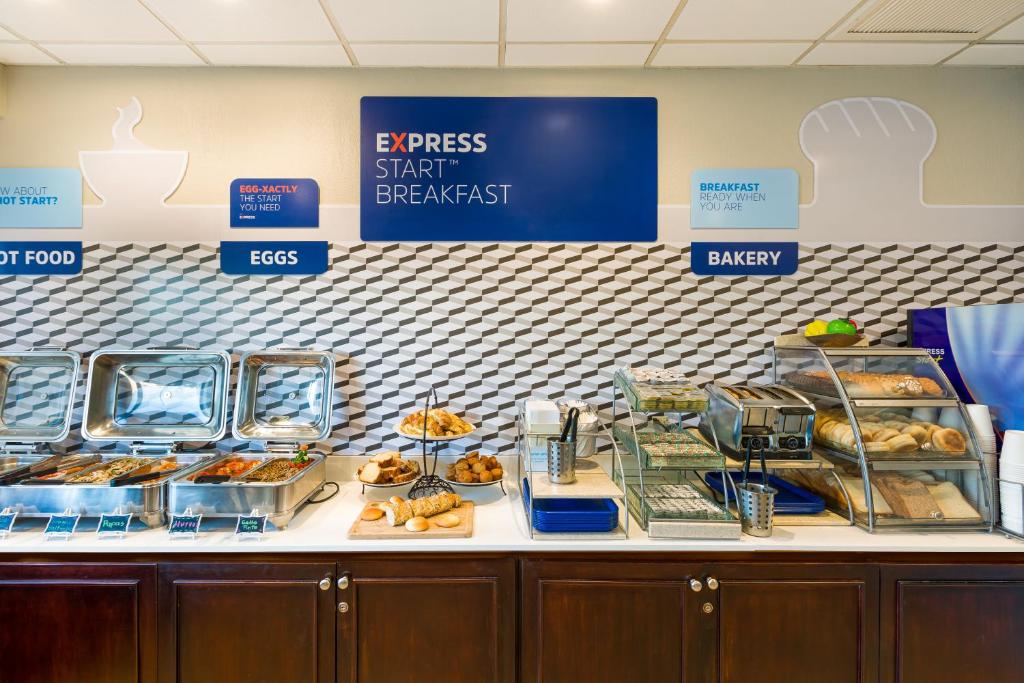 
a kitchen counter filled with lots of different types of pastries at Holiday Inn Express San Jose Airport, an IHG Hotel in Alajuela
