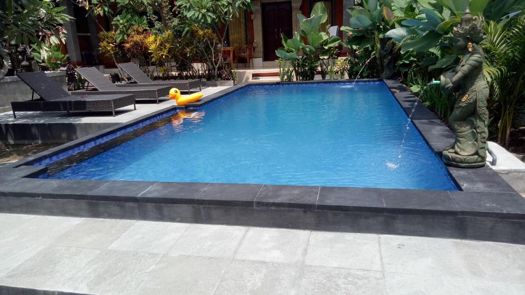 a large swimming pool with a toy in the middle at Happy Inn 2 in Ubud
