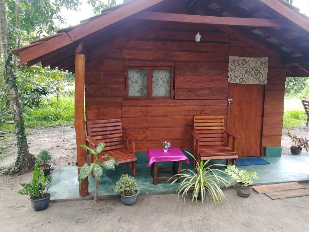 a small wooden cabin with two chairs and a table at Jungle Paradise in Galle