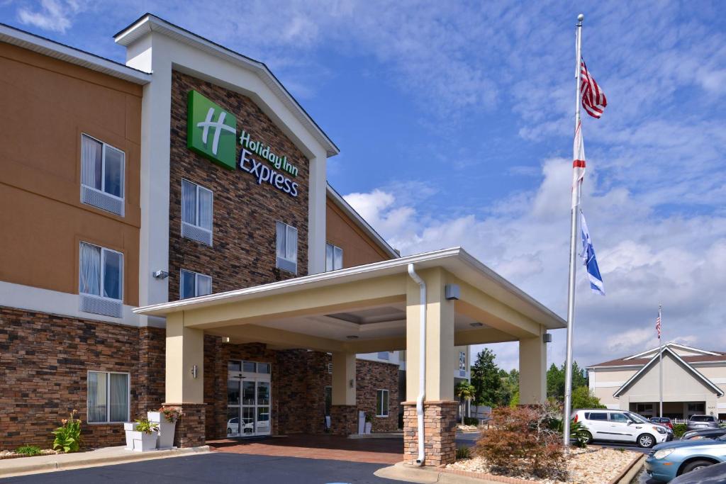 um exterior de hotel com duas bandeiras num parque de estacionamento em Holiday Inn Express Montgomery East I-85, an IHG Hotel em Montgomery