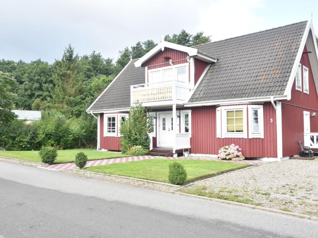 a red house with a black roof at Wohnung in Wittenbeck mit Terrasse in Wittenbeck