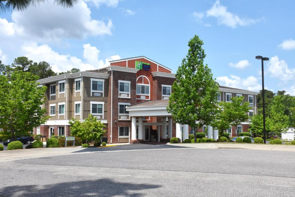 a large building with a tree in front of it at Holiday Inn Express & Suites Southern Pines-Pinehurst Area, an IHG Hotel in Southern Pines