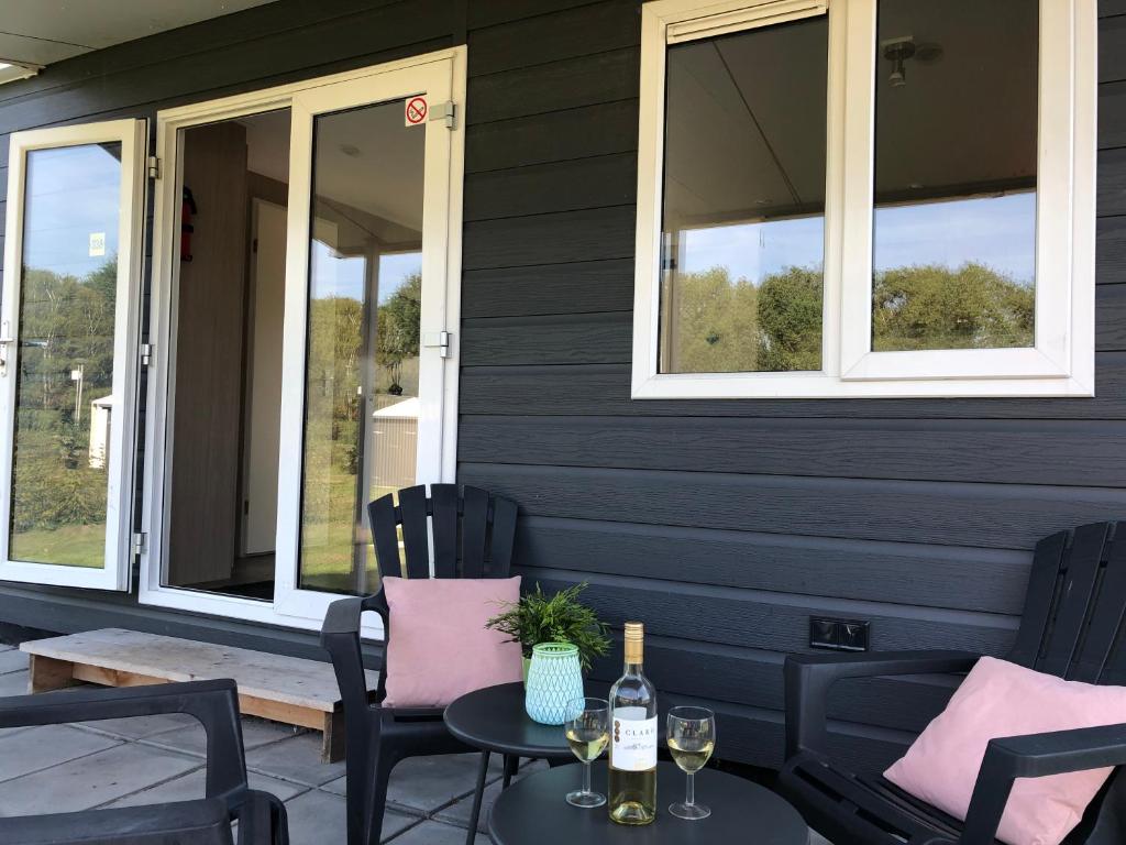 um pátio com cadeiras e uma mesa com garrafas de vinho em Witven em Veldhoven