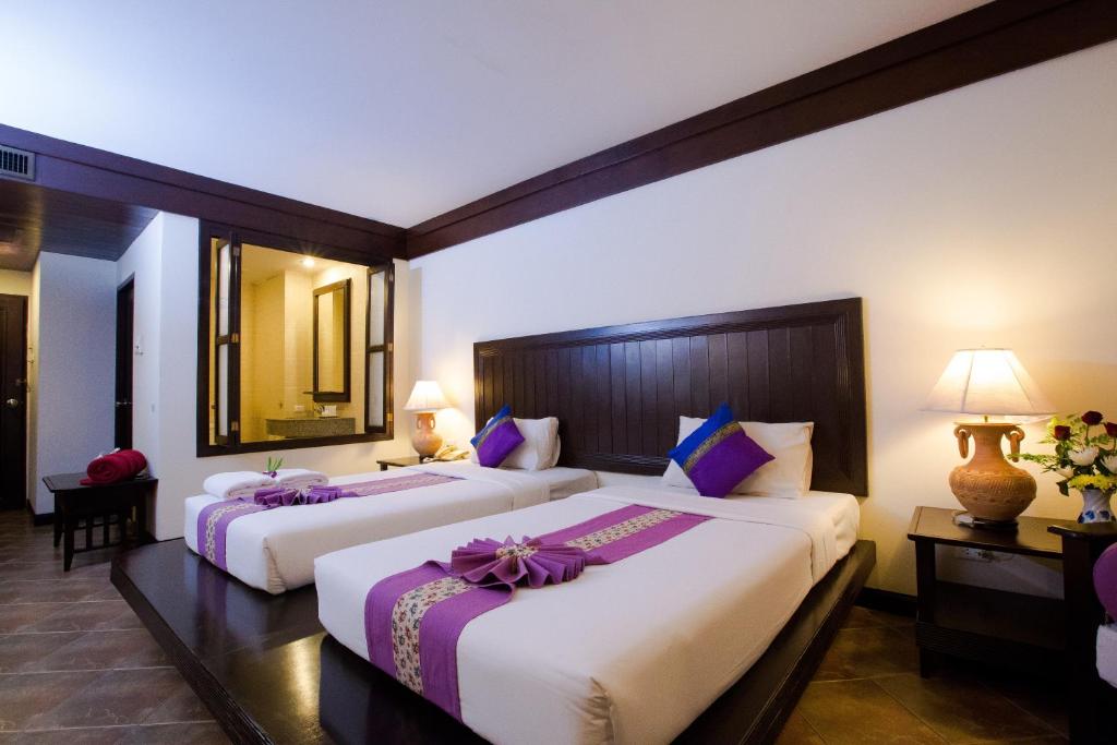 Postel nebo postele na pokoji v ubytování Kata Poolside Resort SHA Extra Plus