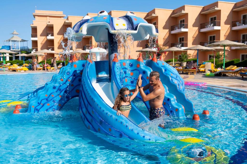 Ein Mann und eine Frau auf einer Wasserrutsche in einem Resort in der Unterkunft Three Corners Sunny Beach Resort in Hurghada