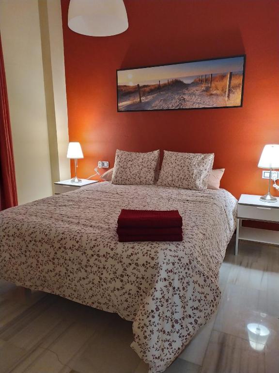 a bedroom with a bed with a red wall at CENTRICO Y LUMINOSO CON 2 DORMITORIOS. A/C + WIFI in Seville