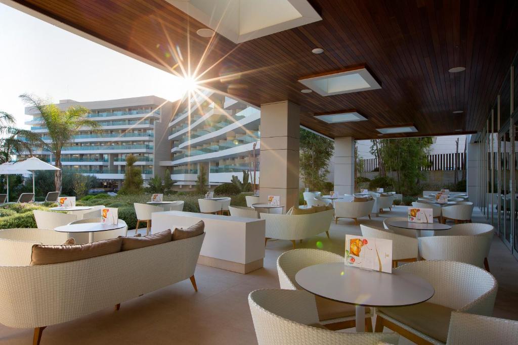 a restaurant with tables and chairs and a building at Hipotels Playa de Palma Palace&Spa in Playa de Palma