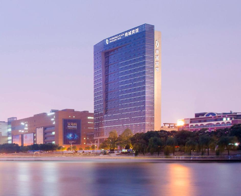 un edificio alto frente a un cuerpo de agua en Yiwu Shangcheng Hotel, en Yiwu