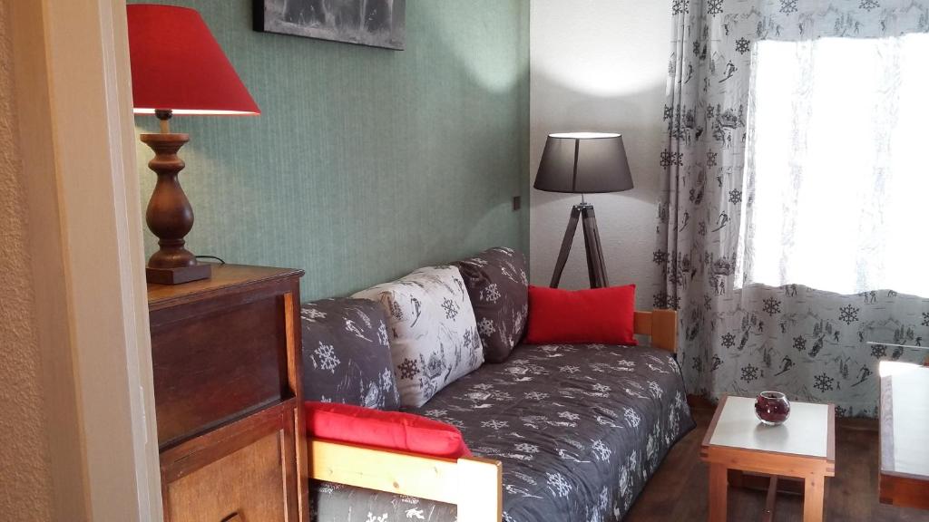 ein Wohnzimmer mit einem Sofa und einer Lampe in der Unterkunft Les 3 marmottes- le Solaret in Bourg-Saint-Maurice