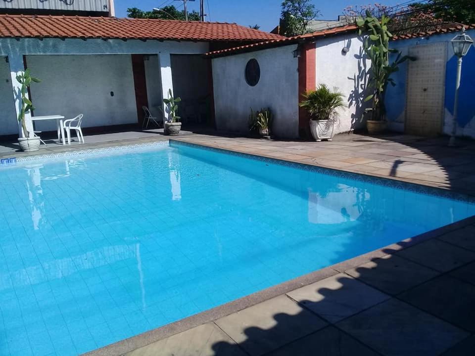 una gran piscina azul frente a una casa en Casarão com piscina e churrasqueira, en Río de Janeiro