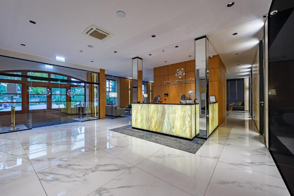 a lobby with a reception desk in a building at Hotel Prezydent in Spała