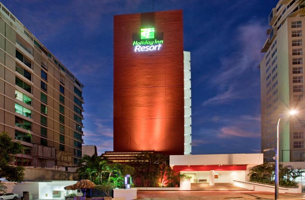 a tall building with a clock on the side of it at Holiday Inn Resort Acapulco, an IHG Hotel in Acapulco