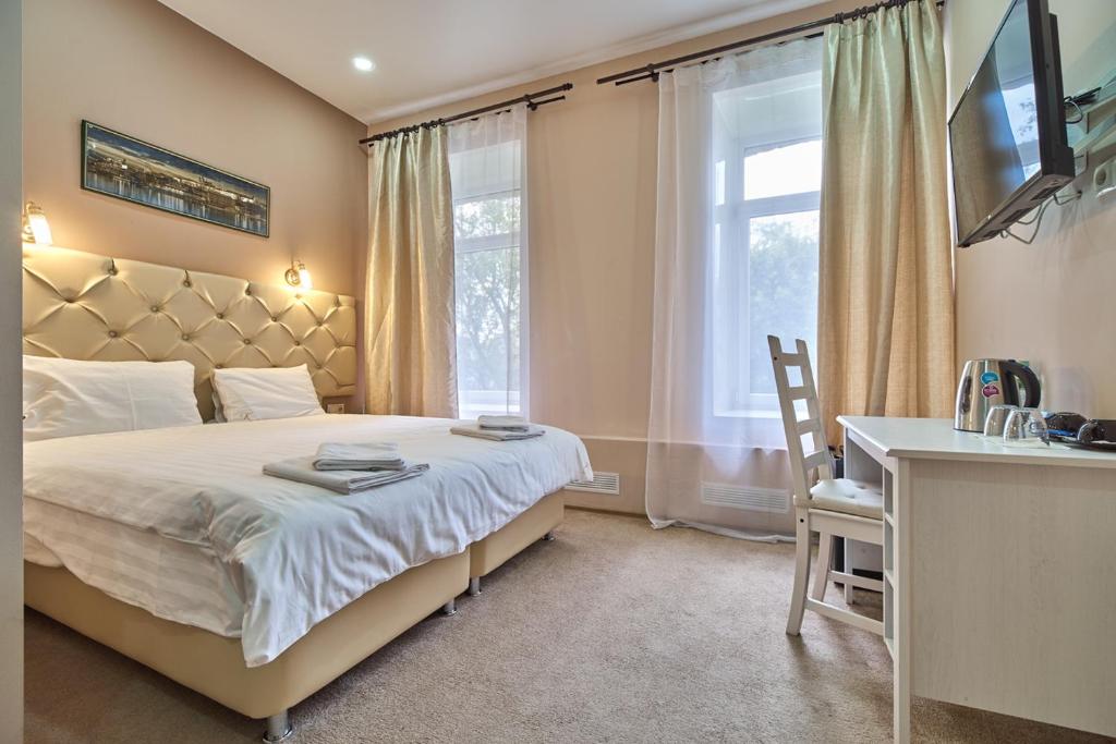 a bedroom with a bed and a desk and a window at Lubyanka Rooms in Moscow