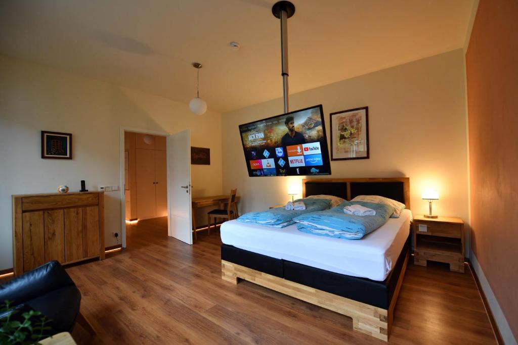 a bedroom with a bed with a tv on the wall at Apartment Nürnberg Like Home in Nuremberg