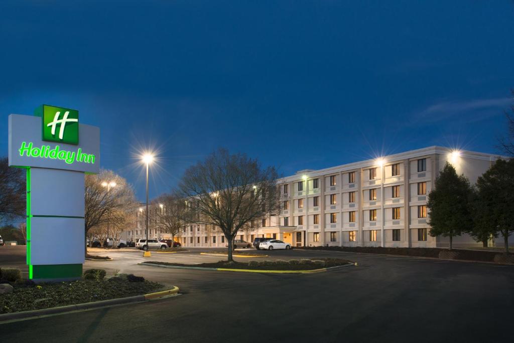 Holiday Inn Charlotte Airport, an IHG Hotel في تشارلوت: فندق فيه لافته امام مبنى